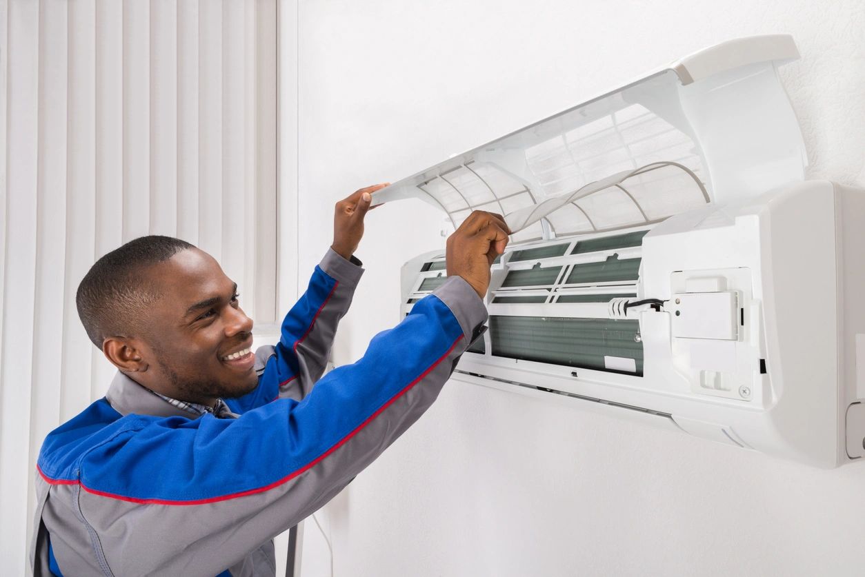 Technician servicing wall-mounted air conditioner